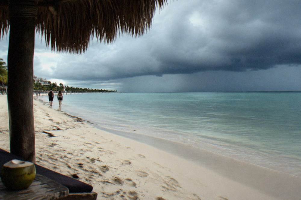 Dark storm clouds gathering over the Caribbean coastline and calm water