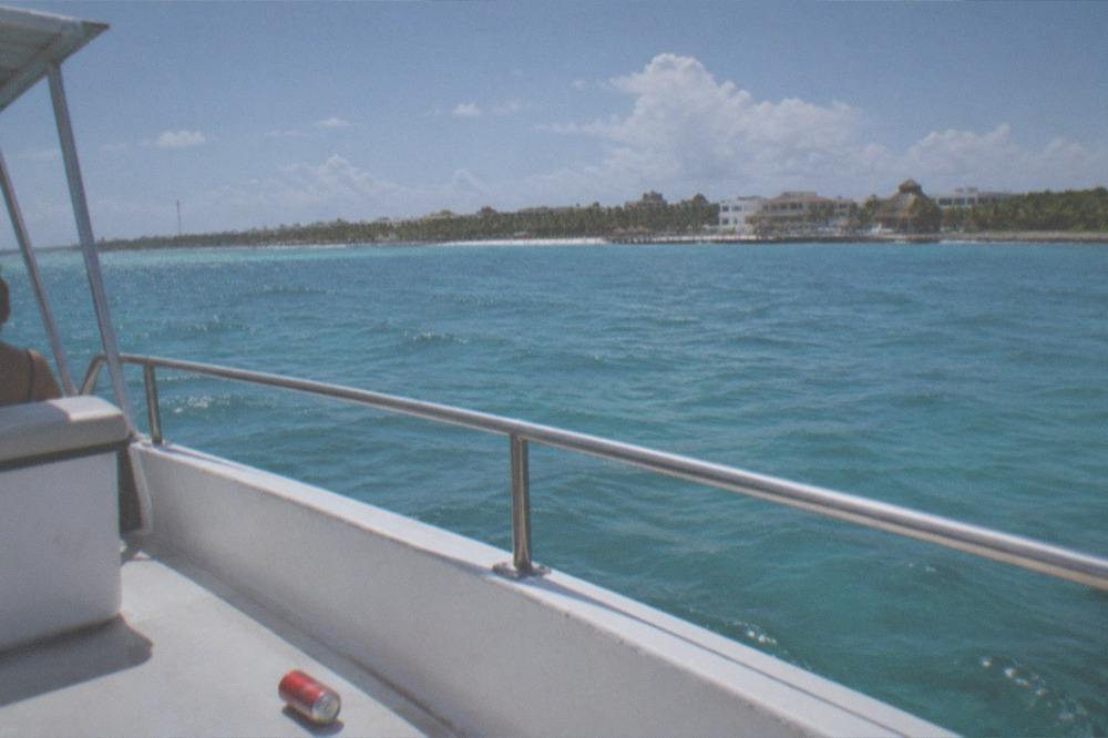 Calm turquoise channel water with an island coastline on the horizon at midday