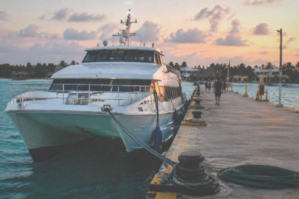 A passenger ferry docked at a pier with turquoise water on either side
