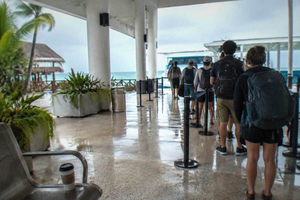 Ferry terminal ticket hall with passengers waiting beside boarding gates