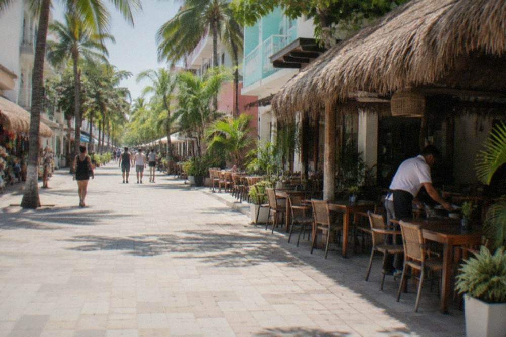 Fifth Avenue pedestrian street lined with shops and restaurants in Playa del Carmen at midday